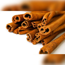 Charger l'image dans la galerie, L'image montre plusieurs bâtons de cannelle empilés, mettant en valeur leur texture et leur forme enroulée.